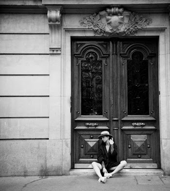 Monochrome Photo Of Woman Sitting In Front Of Door
