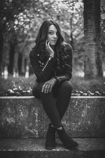 Monochrome Photo of Woman Sitting On Ledge