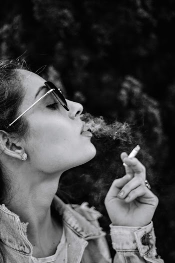 Monochrome Photo of Woman Smoking Cigarette