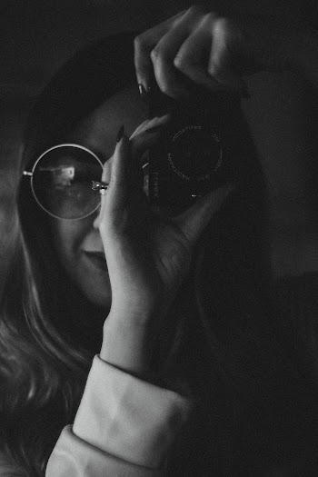 Monochrome Photo of Woman Using Camera