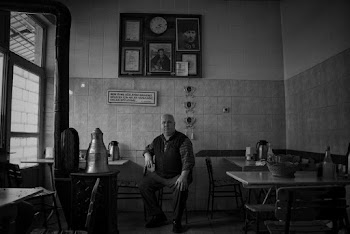 Monochrome Photography of a Man Sitting on Chair Inside a Restaurant