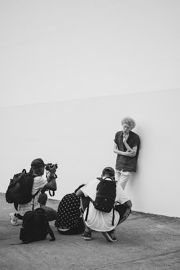 Monochrome Photography of Man Leaning on Wall