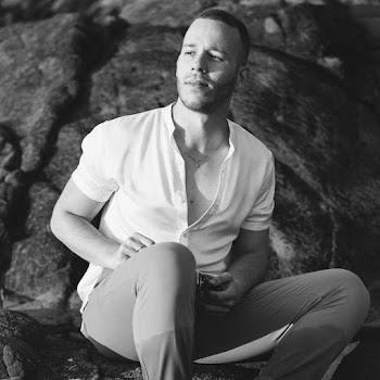 Monochrome Photography Of Man Sitting On Rock