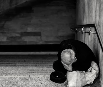 Monochrome Photography of Man Sitting on Staircase