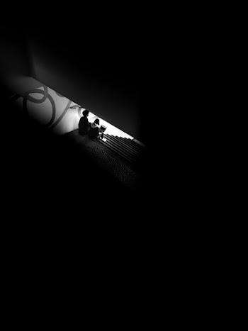 Monochrome Photography of People Seated on Stairs