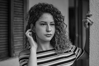 Monochrome Photography of Woman Standing Near Post