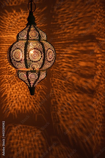 Moroccan golden lamp with circular patterns of light on wall for bohemian theme.