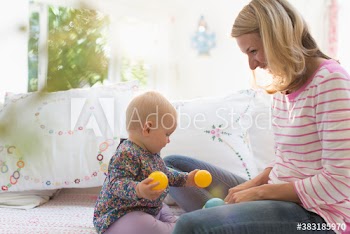 Mother and baby daughter playing with balls
