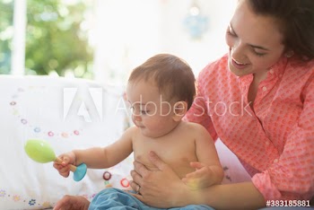 Mother and baby son playing with toys