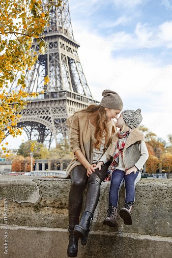 mother and daughter travellers sitting on the parapet in Paris