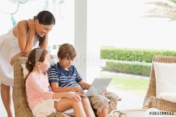 Mother and kids using laptop on patio