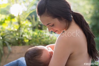 Mother breastfeeding baby son on patio