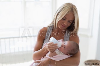 Mother feeding baby girl with bottle