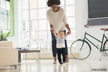 Mother helping baby son learn to walk