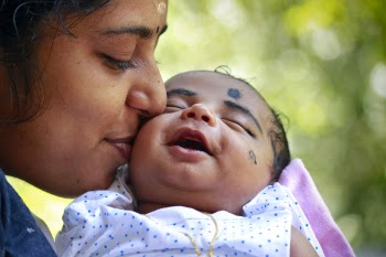 Mother Kissing Child On Cheek
