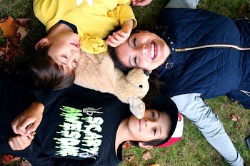 Mother Laughing With Her Children In Grass