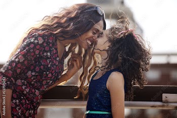 Mother rubbing nose with daughter on terrace