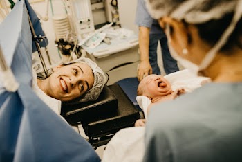 Mother Smiling Looking at Newborn Child