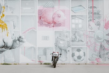 Motorcycle Parked in Front of Artwork Wall