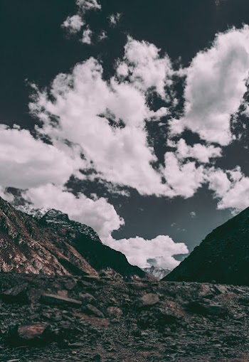 Mountain and Field Under White Skies