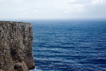 mountain cliff surrounded by body of water during daytime