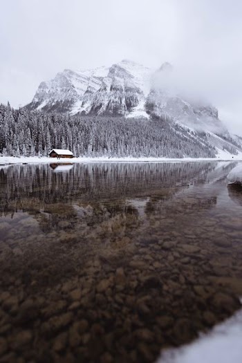 mountain covered with snow near body of water