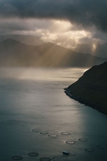 mountain near body of water under cloudy sky