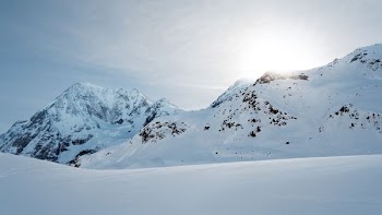 mountain range with snow and cloudy sky