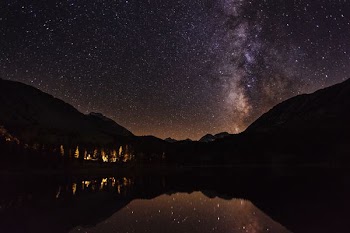 mountain reflecting on body of water at nighttime
