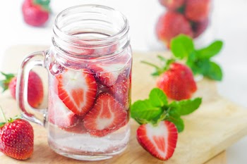 Mug delicious refreshing drink of strawberry on wooden, infused water