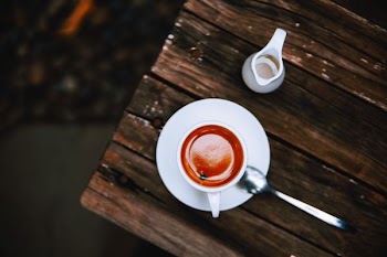 mug filled with cappuccino on saucer