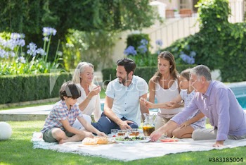 Multi-generation family enjoying picnic in sunny garden