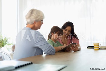 Multi-generation family using digital tablet at dining table