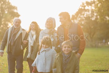 Multi-generation family walking in sunny autumn park