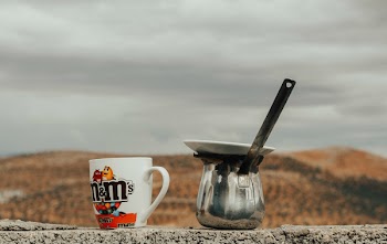 Multicolored M&amp;m's Ceramic Cup Beside Gray Stainless Steel Cezve Pot