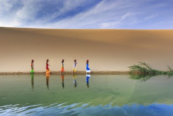 Multicolored Painting of Women Standing Beside Body of Water