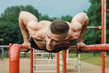 Muscular man during his workout on the street