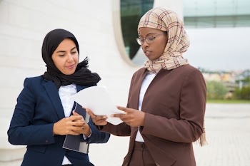 Muslim business women discussing contract text Free Photo