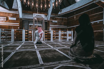 Muslim man and woman praying in mosque