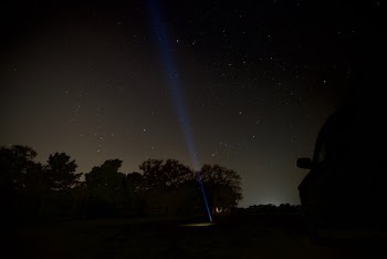 My old truck parked against the night sky, with a flashlight poking to the trees.