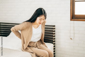 腰痛の女性（ベッドルーム）
