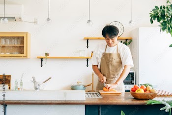 キッチンに立つ男性（野菜を切る）

