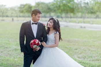 New Wed Couple Standing on Field and Pose for Picture