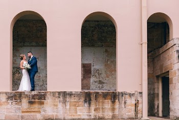 Newly Wed Standing Beside White Concrete Building