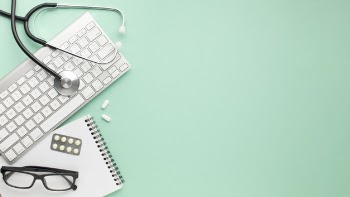 Notepad; wireless keyboard with stethoscope and medicines over surface Free Photo