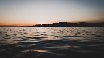 ocean water and silhouette of mountains landscape photography