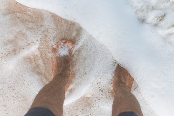 Ocean Water Washing over Man's feet