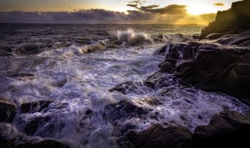 Ocean Waves Crashing on Rocks during Sunset