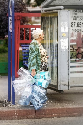 Old Woman Holding Empty Plastic Water Bottles Standing Near Road