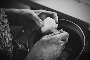 Old woman peeling an egg